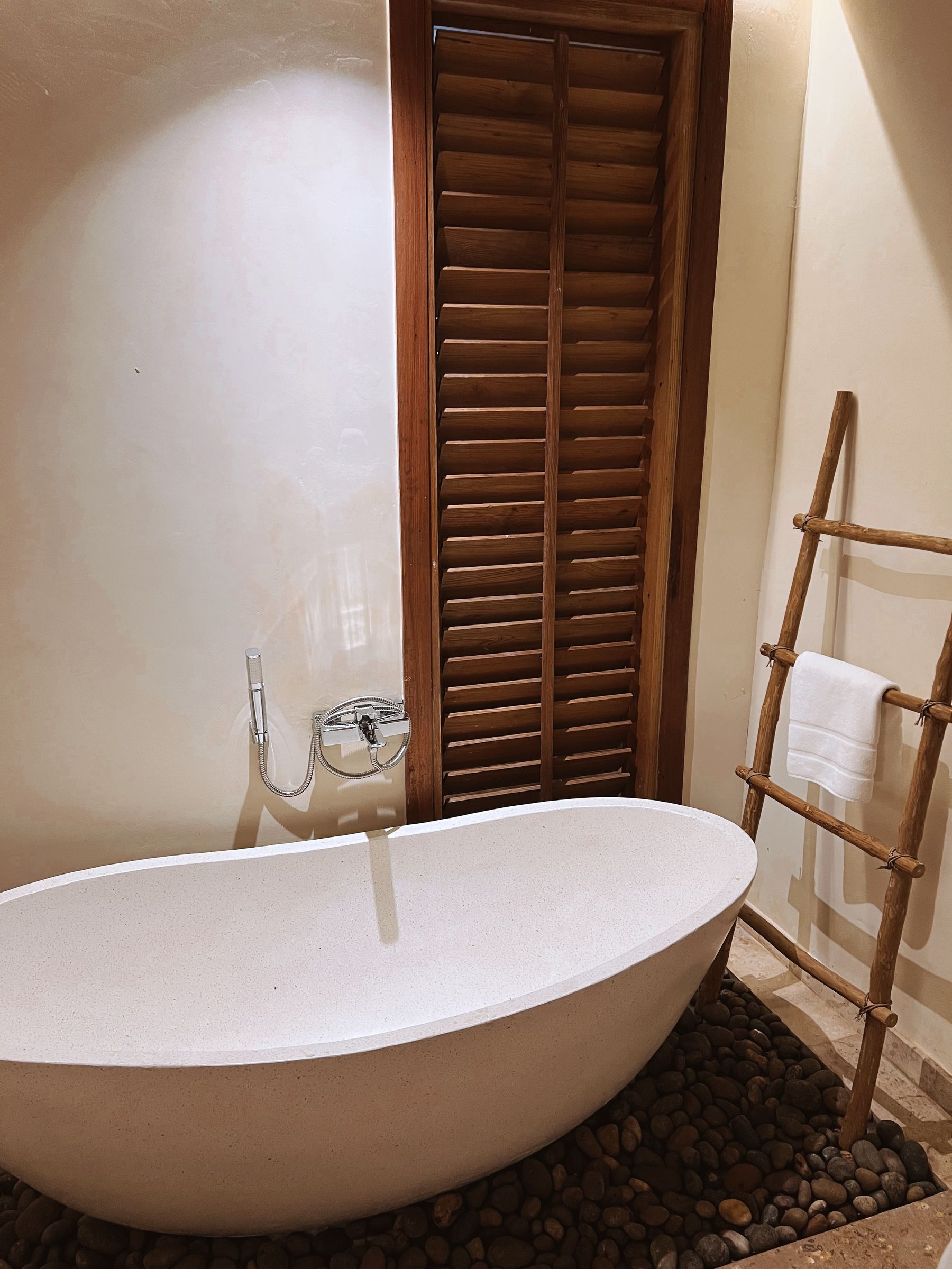 Calm spa-style bathroom with freestanding tub, warm timber and quiet mineral surfaces