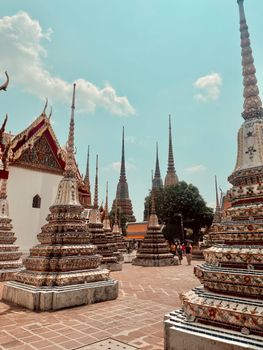 Ornate stupas and temple structures at a bustling Bangkok religious site.