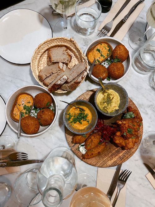 Free Delicious assortment of gourmet tapas with dips on a marble table setting, perfect for a social gathering. Stock Photo