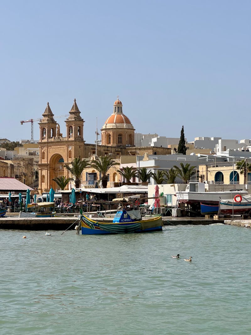Colourful luzzu fishing boats in Marsaxlokk harbour Malta