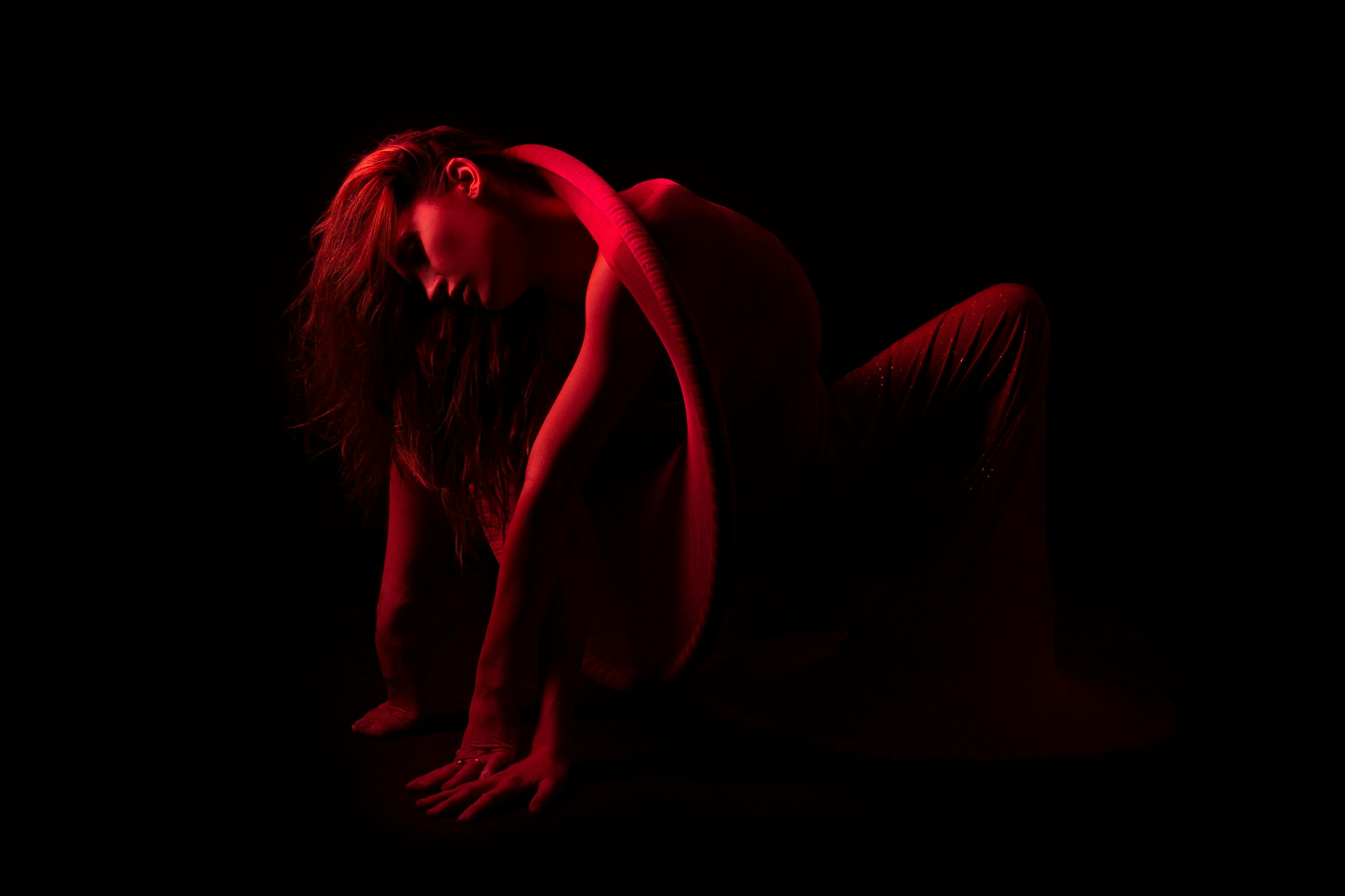 bending woman in dark room