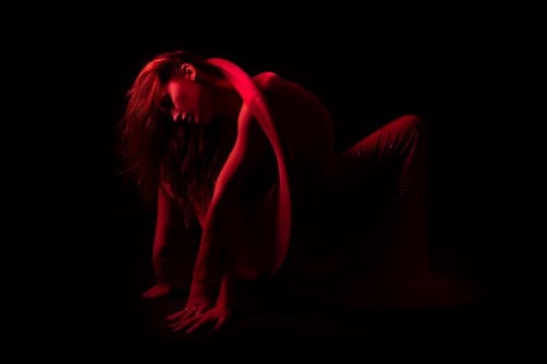 Bending Woman in Dark Room