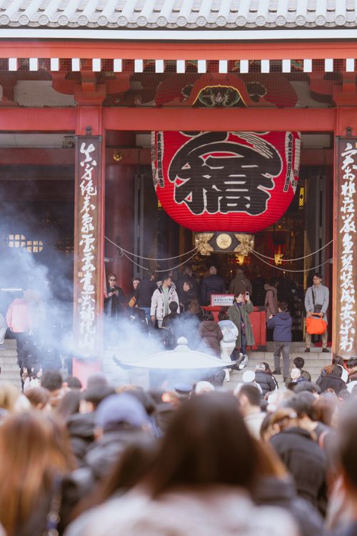 Free A bustling scene at Senso-ji Temple in Tokyo with visitors and traditional architecture. Stock Photo