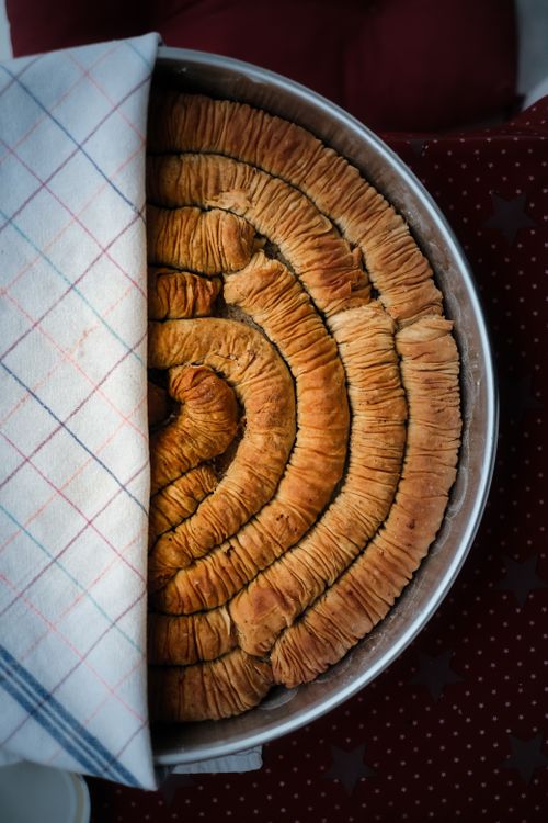 Free Freshly baked spiral pastry in a round tray, partially covered with cloth. Stock Photo