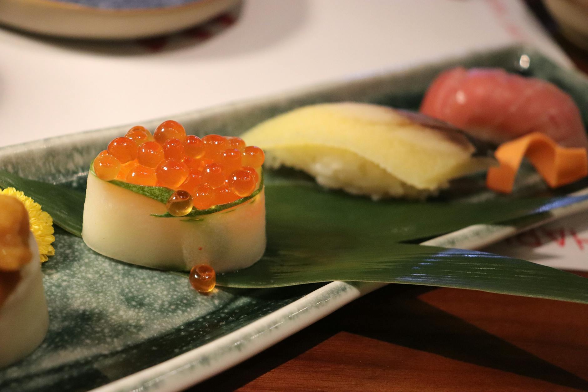 Ikura Sushi Roll With Salmon Roe, Rice, And Nori On A Wooden Sushi Board