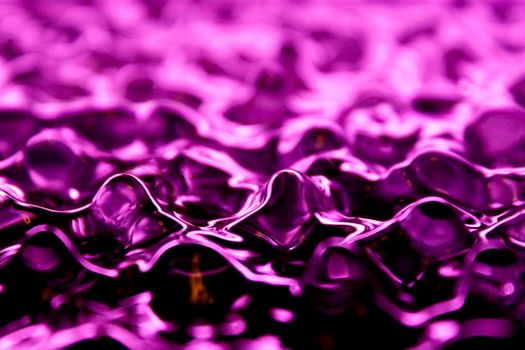 Vibrant purple abstract texture resembling fluid or fabric ripples. Ideal for backgrounds.