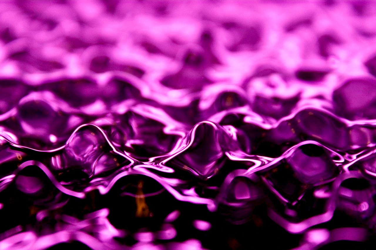 vibrant purple abstract texture resembling fluid or fabric ripples ide