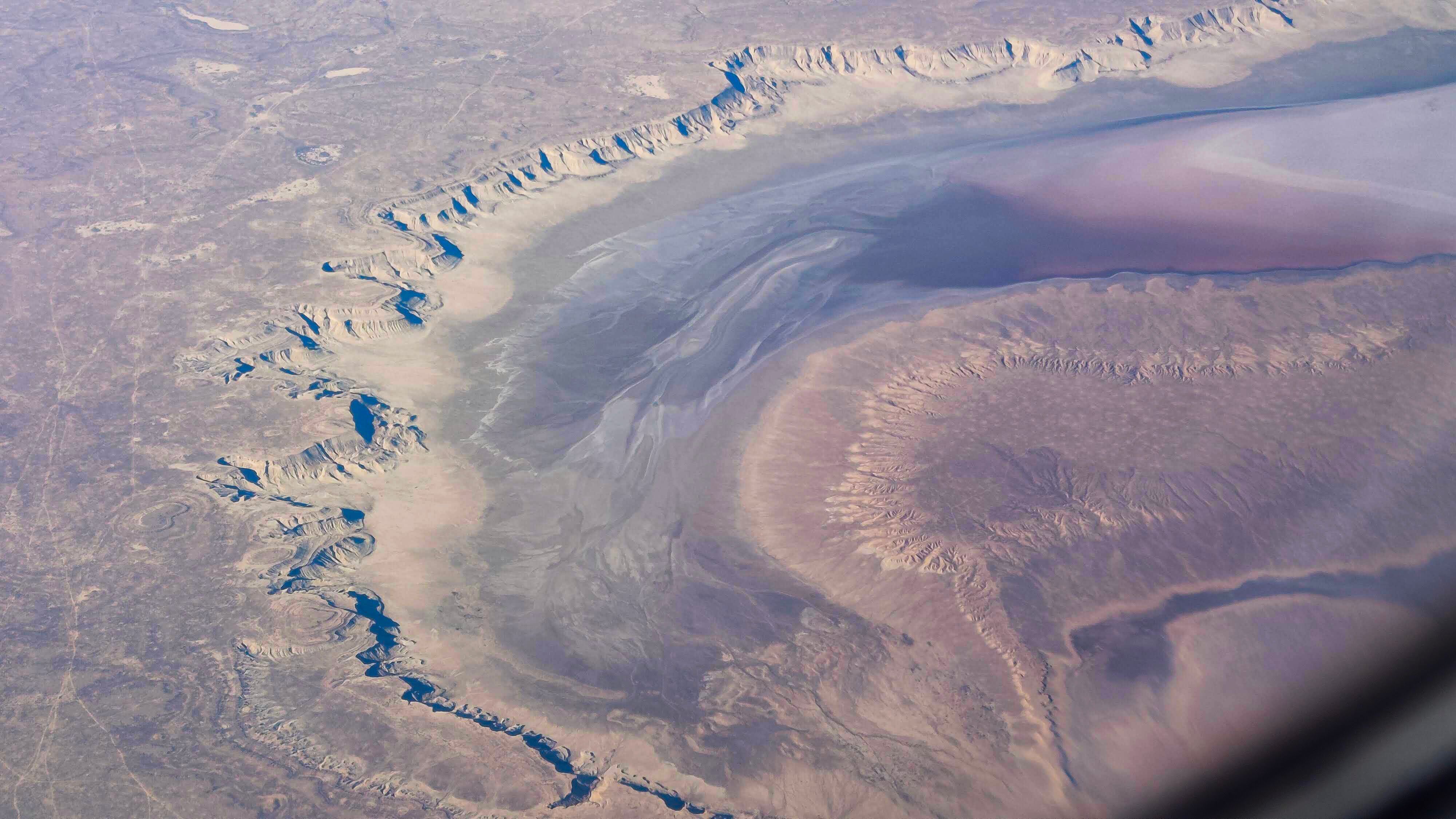 Aerial view of a rugged and barren desert landscape with geological formations.