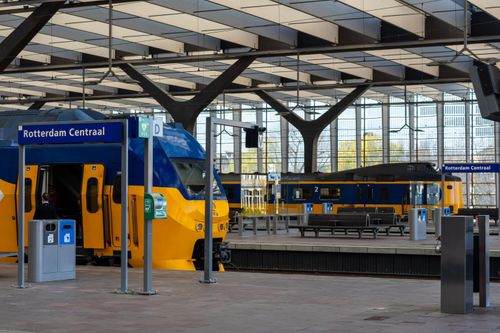 Free Contemporary design of Rotterdam Centraal with blue and yellow trains. Stock Photo