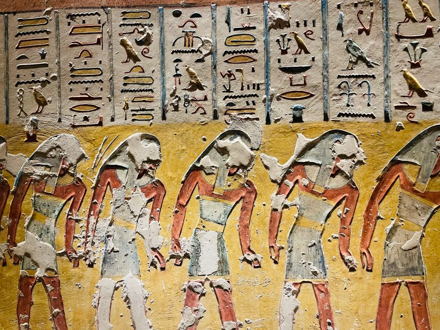 Photograph of ancient Egyptian hieroglyphics and colorful art depicting figures on a historical wall.