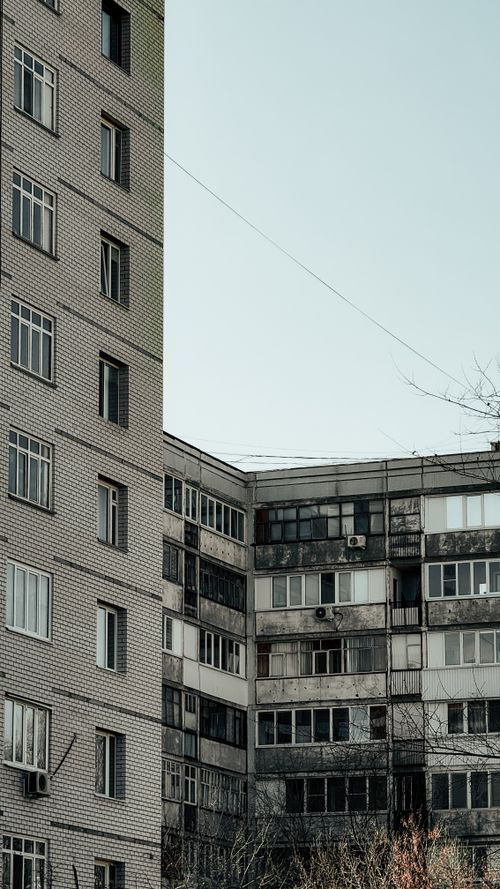 Free Minimalist urban apartment buildings with a vintage architectural style under a clear sky. Stock Photo