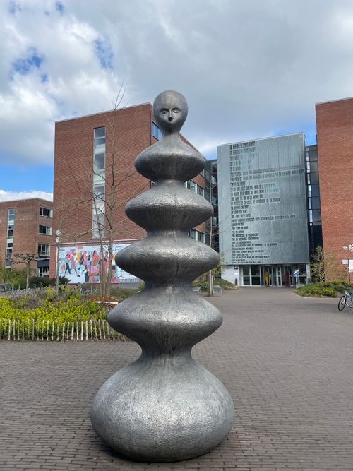 Free Imposing modern sculpture in the courtyard of a university campus on a cloudy day. Stock Photo