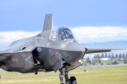 Free Close-up of an F-35 fighter jet on a runway with a visible pilot, clear sky background. Stock Photo