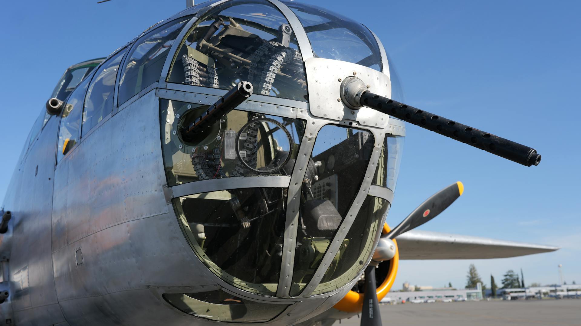 Detailed view of a vintage aircraft nose, showcasing metal structure and guns.