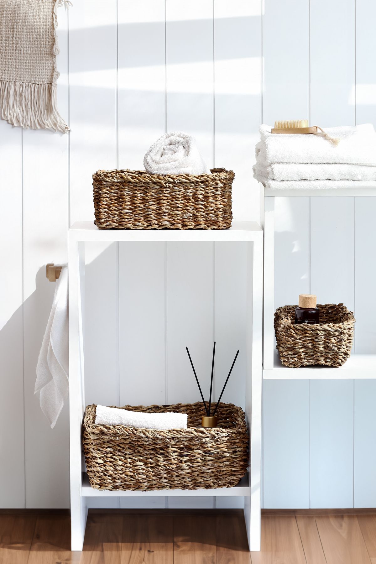 Minimal bathroom shelving with wicker baskets towels and organized essentials