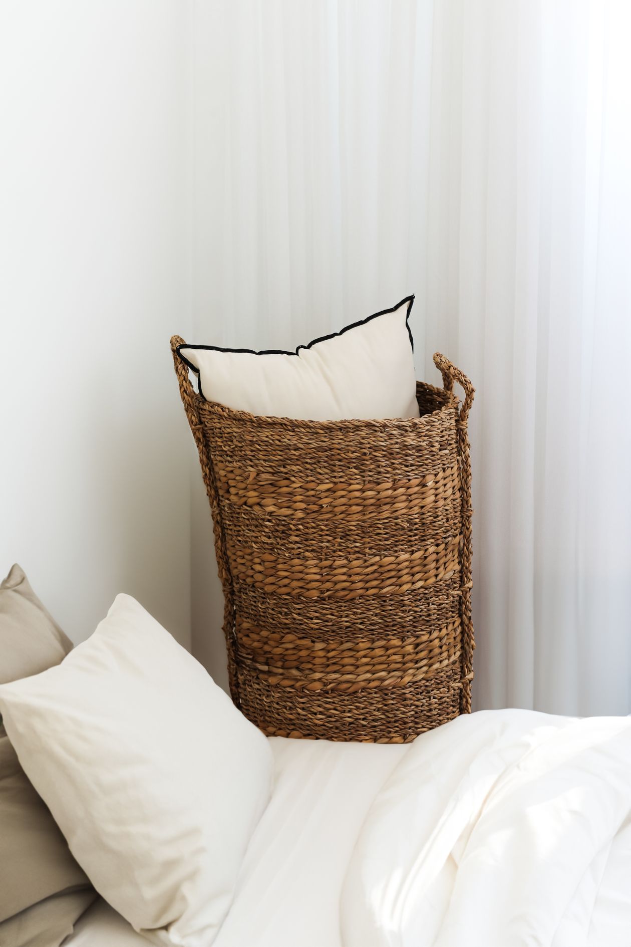 Slim hamper keeping laundry off the floor in a tiny bedroom.