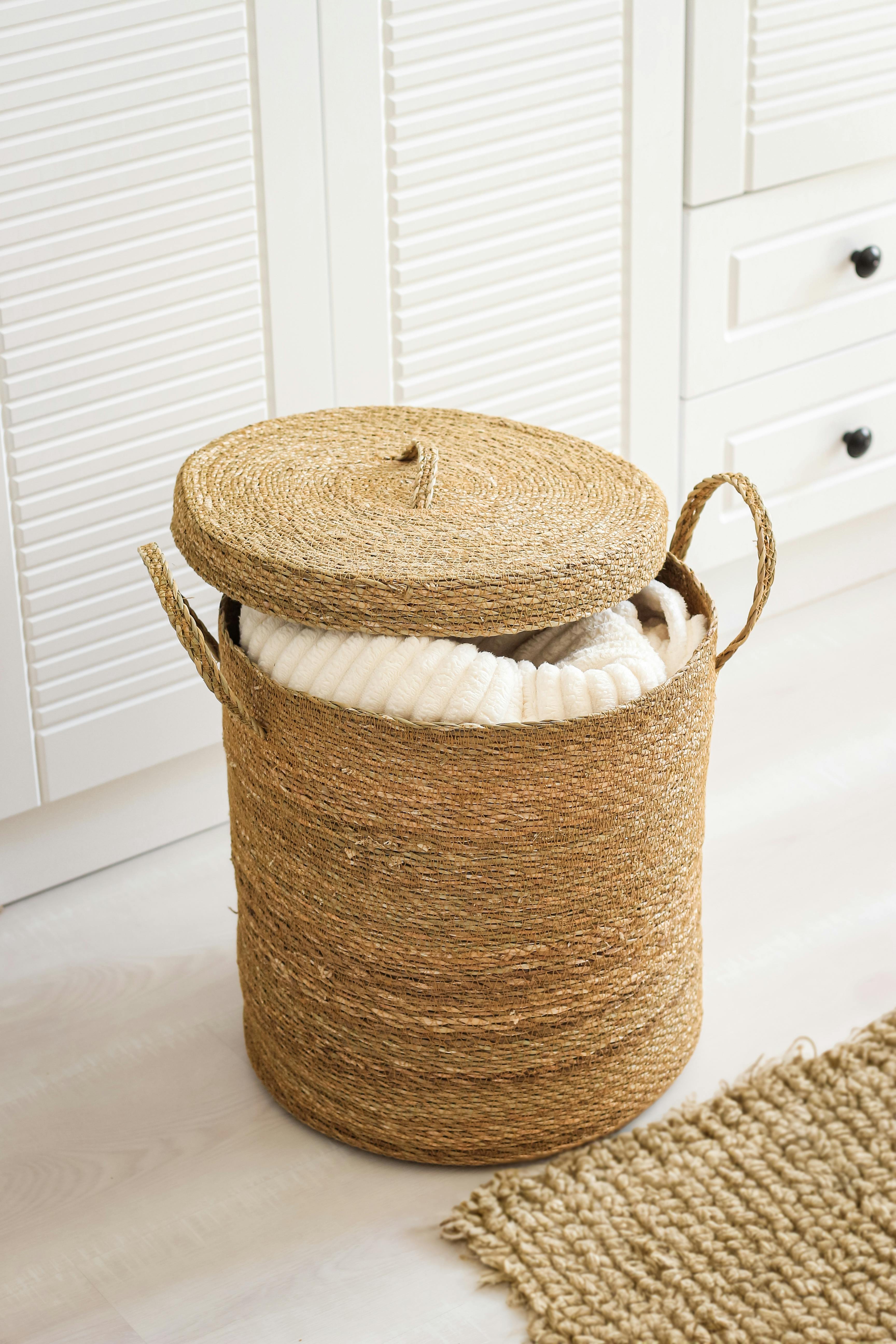 A stylish woven basket filled with a cozy blanket, perfect for home decor.