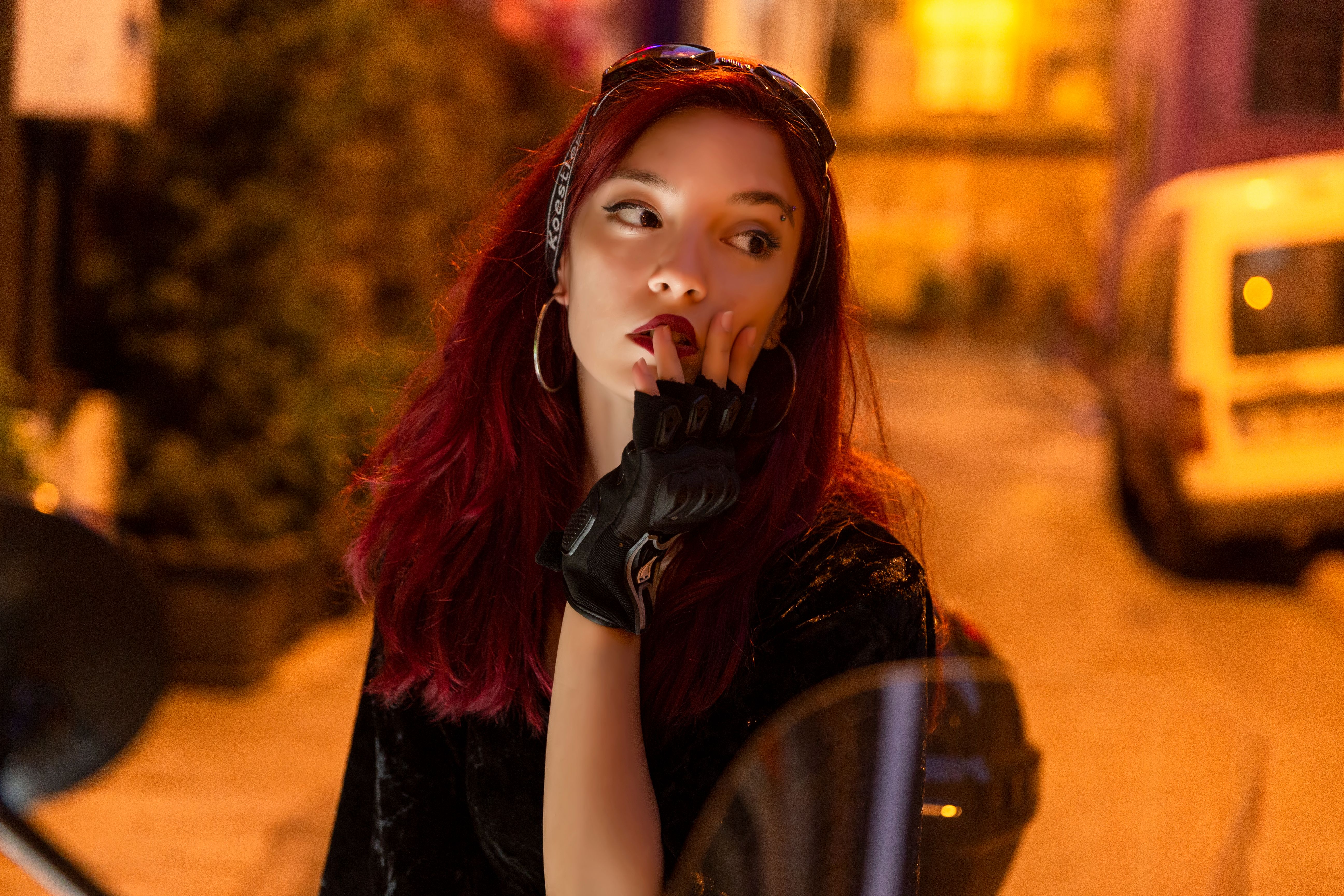 Yapay Zeka Karar Verdi: Türkiye'nin En Güzel 5 İsmi Kim? - Portrait of a woman with red hair and gloves posing outdoors at night, exuding urban fashion.