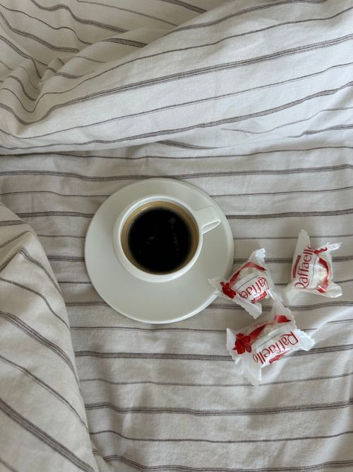 Free A cup of espresso on a striped blanket with wrapped candies Stock Photo