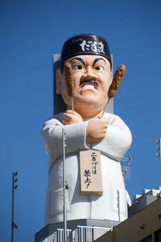 A striking statue of a chef holding corn dogs, symbolizing culinary culture.