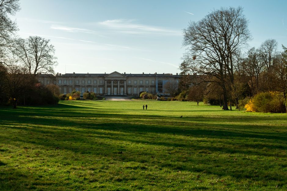 Peaceful view of Château de Compiègne with lush gardens under clear skies in springtime.