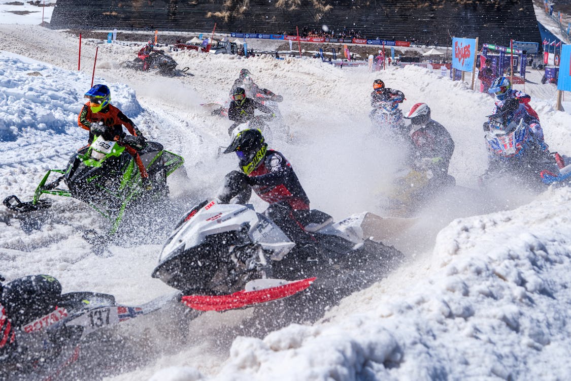Exhilarating Snowmobile Race in Winter Terrain · Free Stock Photo