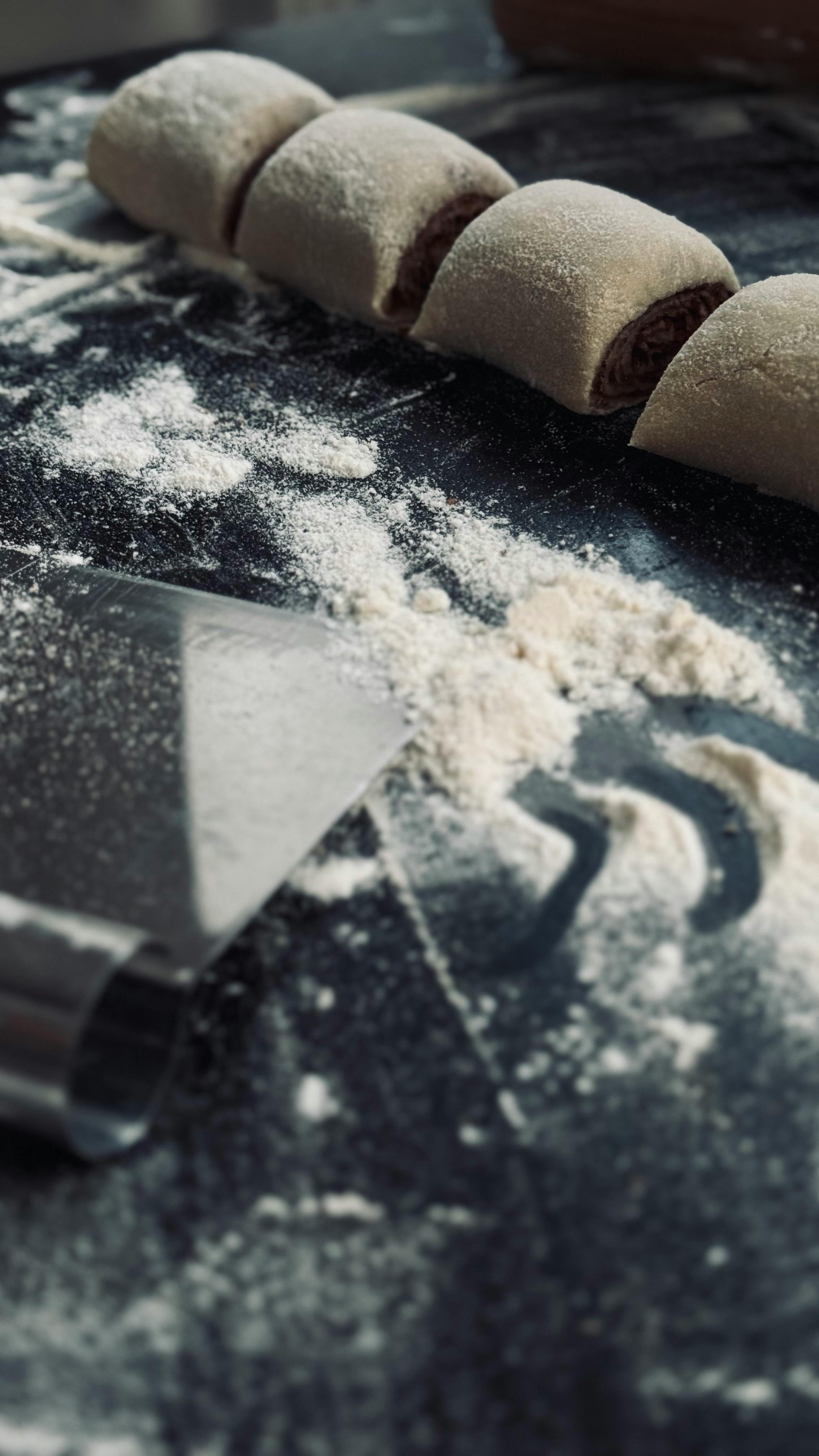 Gratuit Prim-plan cu aluat de patiserie rulat pe masa înfăinată, creând vibrații de panificație. Fotografie de stoc