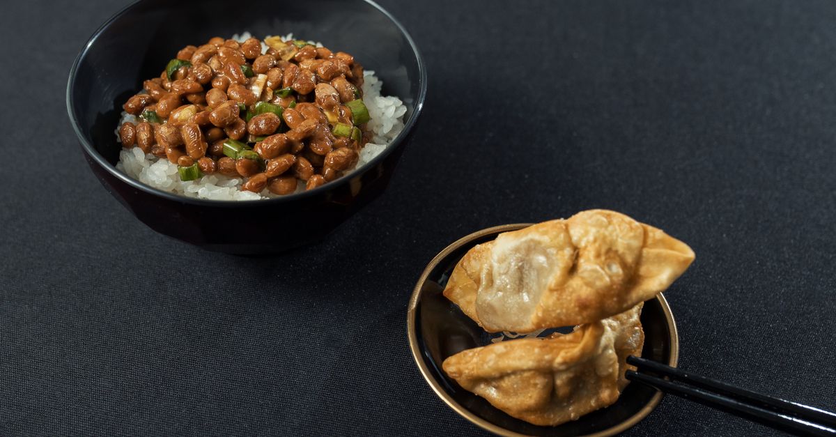 Appetizing bowl of Japanese natto rice and dumplings on a sleek black surface. - Evidence evidence guide for fermented soy sleep randomized trial