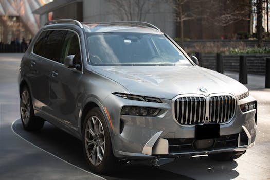 A silver luxury SUV parked outdoors in a modern urban area of New York City.
