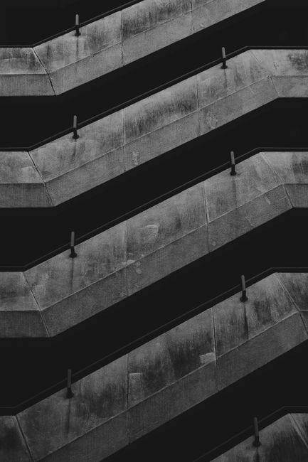 A dramatic black and white shot of a modern concrete staircase.