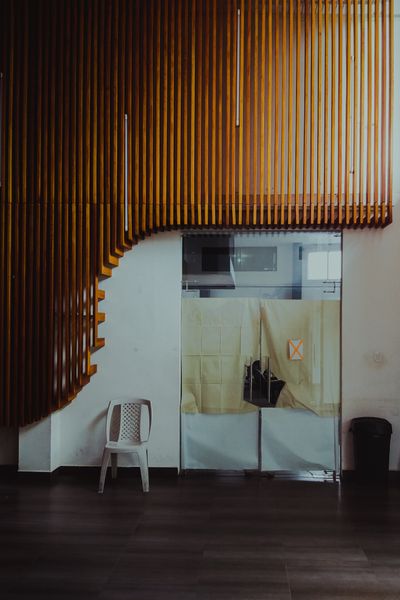 Wooden slat ceiling sweeping into a white room, photo by Antonio Prado on Pexels
