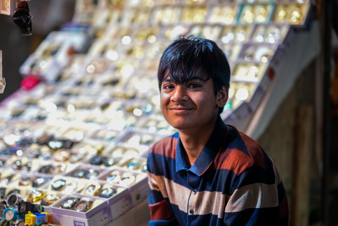 Shopkeeper Real Young Shopkeeper Smiling at Jewelry Stall · Free Stock Photo