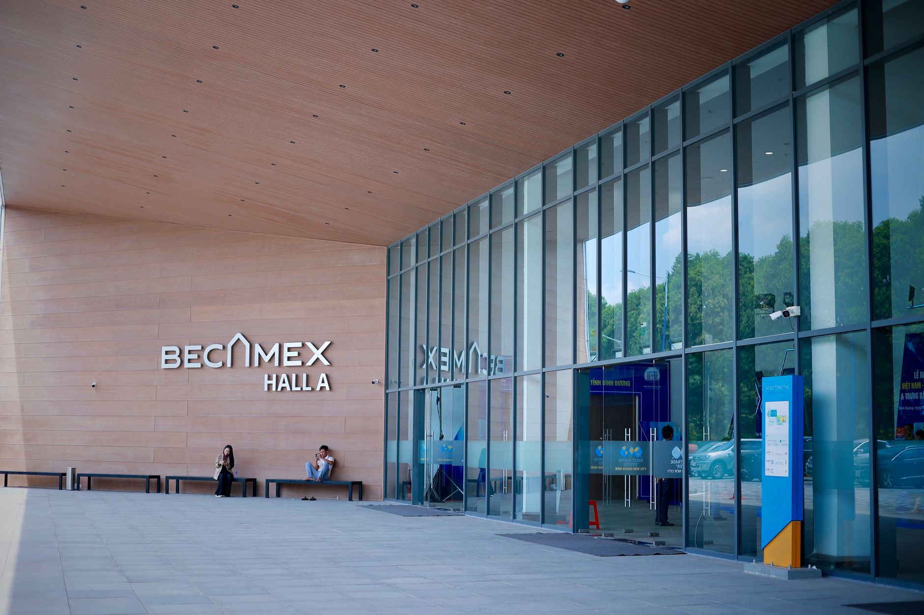 Vue extérieure du Becamex Hall A avec une façade en verre et un design contemporain.