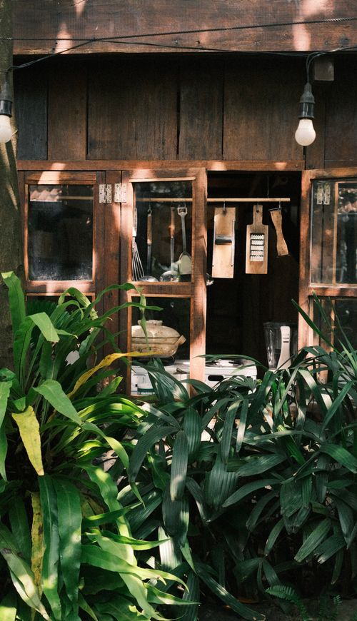 Free Charming rustic kitchen with wooden elements visible through a garden window. Stock Photo
