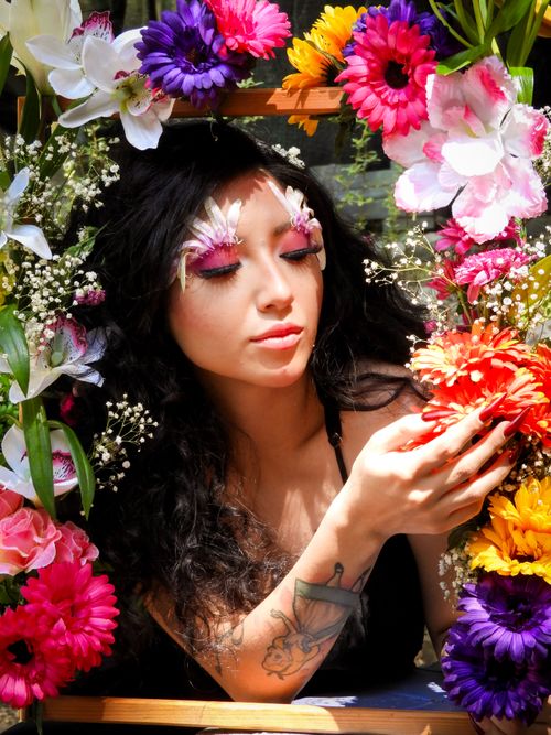 Free A woman with floral makeup in a colorful flower arrangement, embracing spring's essence. Stock Photo