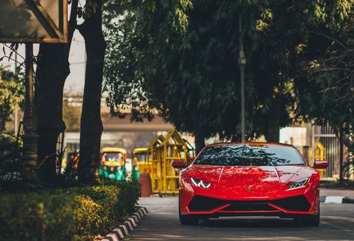 Capture of a striking red Lamborghini Huracan on the streets of New Delhi, showcasing luxury and style.
