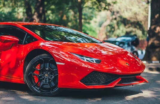 A vibrant red Lamborghini Huracan parked on a sunny day on a street in New Delhi, India.