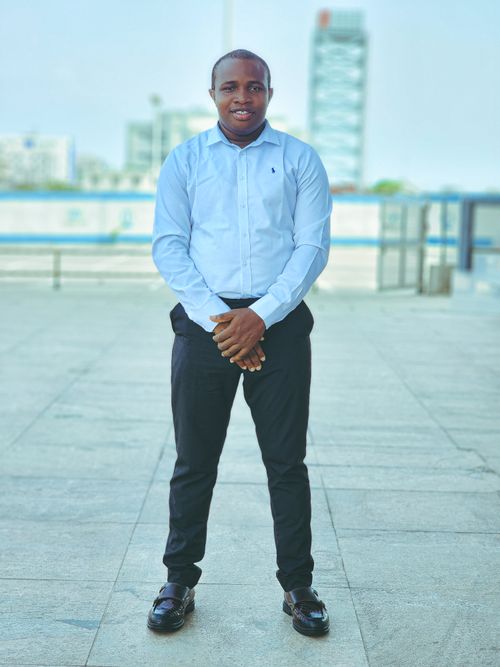 Free A well-dressed businessman poses confidently outdoors in an urban setting, wearing a smart shirt and trousers. Stock Photo