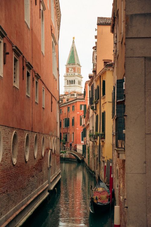 Free Historic canal scene in Venice, featuring vibrant architecture and a gondola. Stock Photo