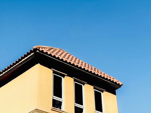Free A Mediterranean style building rooftop with terracotta tiles under a clear blue sky. Stock Photo