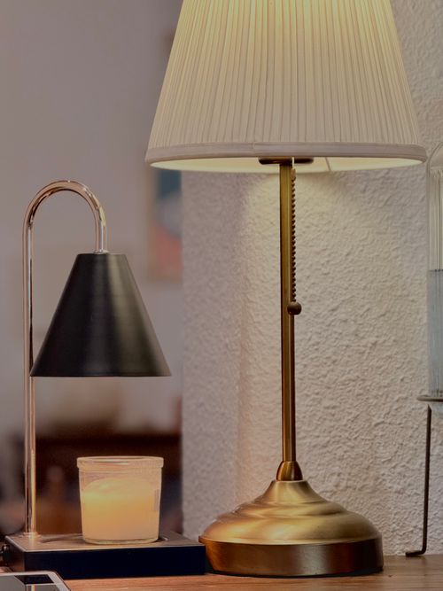 Free Elegant table lamps and candle creating a comforting ambiance in a home setting. Stock Photo