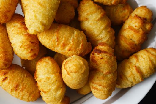A close-up view of golden-brown crispy potato croquettes freshly served on a white plate.