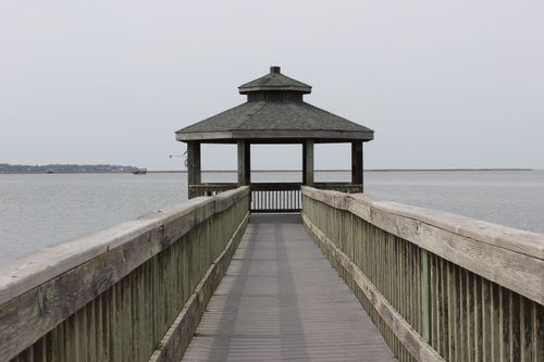 Free Wooden gazebo on a pier extending into a calm lake, perfect for relaxation and nature views. Stock Photo