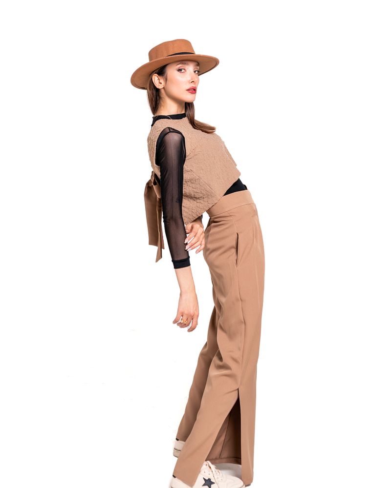 Celana kulot warna krem dipakai model dengan latar putih polos