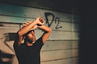 在巴西雷斯泰尔，一位时尚的黑人倚着质朴的木墙摆姿势