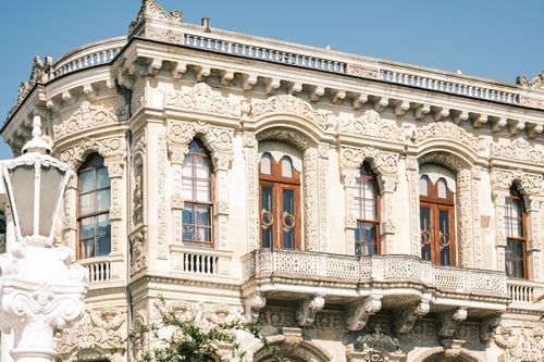 Free Detailed facade of an ornate historic building with balconies under clear blue sky. Stock Photo