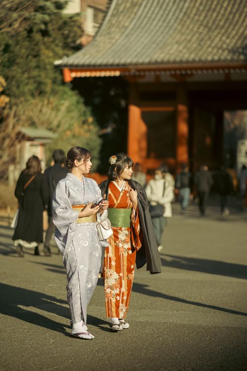 Free Two women in colorful kimonos enjoying a sunny day in Japan, showcasing cultural fashion. Stock Photo