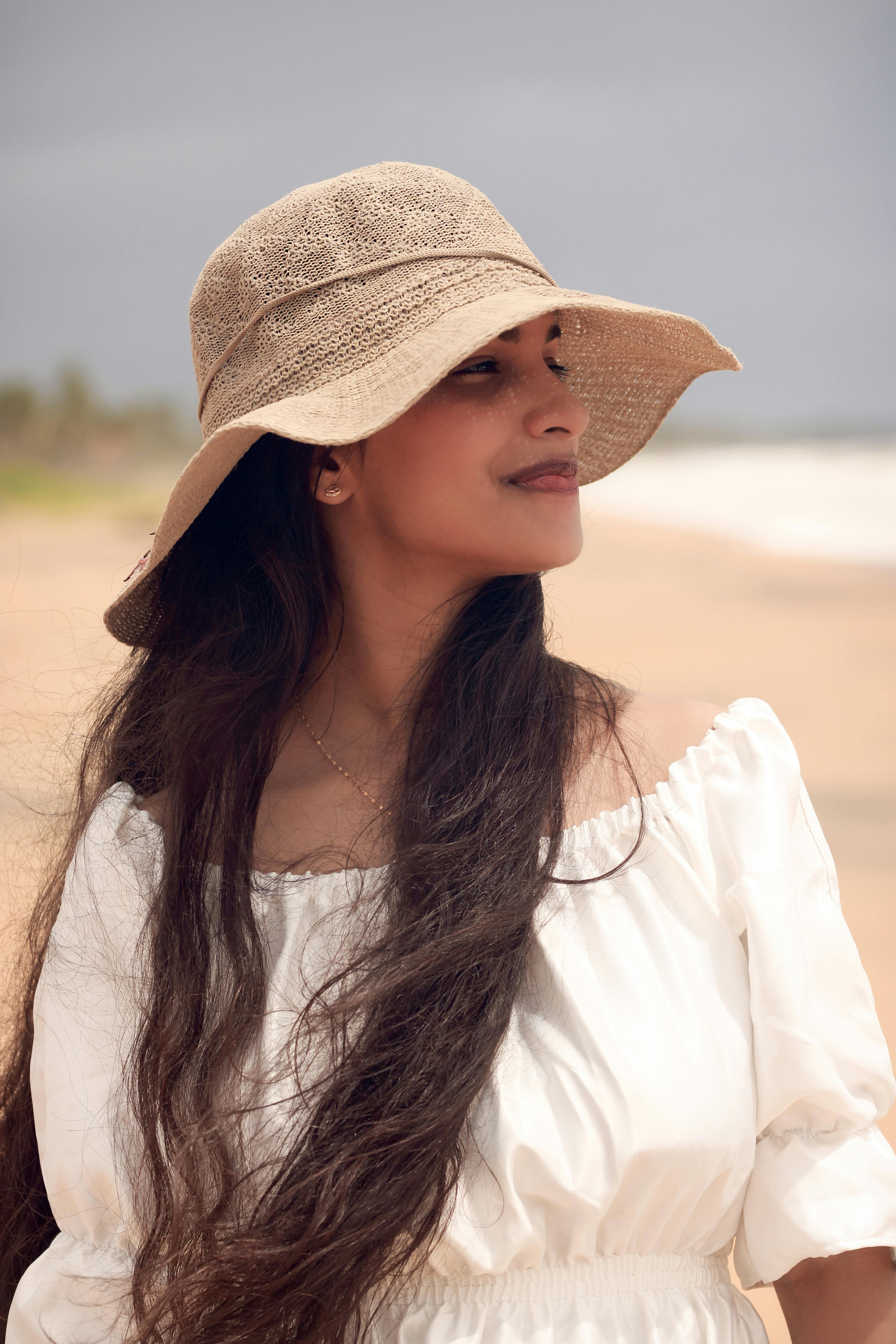 A relaxed woman in a sun hat enjoying a day at the beach, capturing a summer vibe.