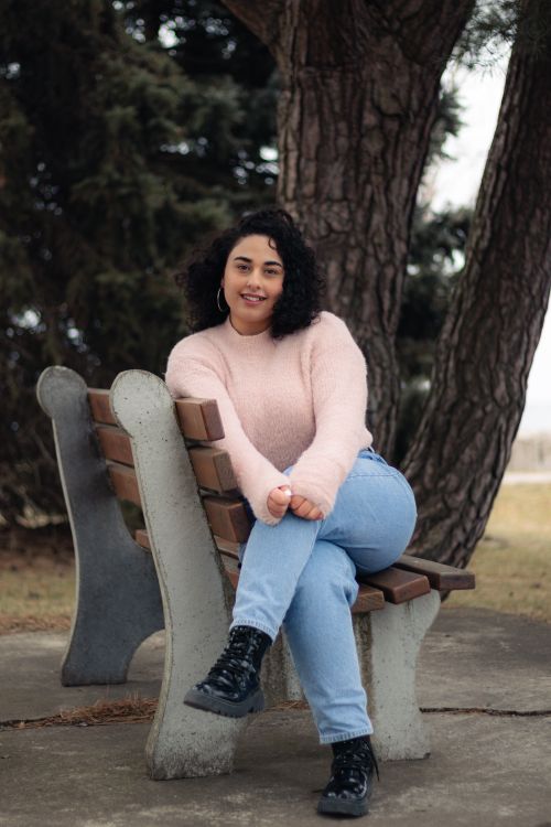 Smiling Woman on Bench in Outdoor Park Setting · Free Stock Photo