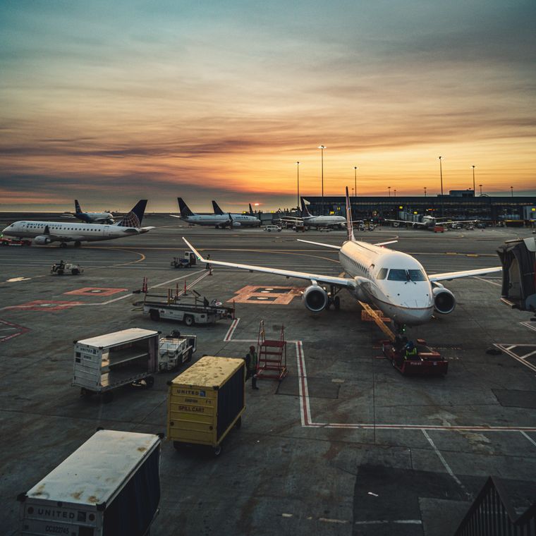 Aircraft waiting on the apron at an airport at sunrise